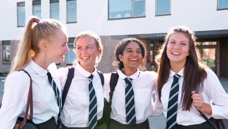 retrato de estudiantes de secundaria sonrientes vestidos con uniforme fuera del edificio de la universidad