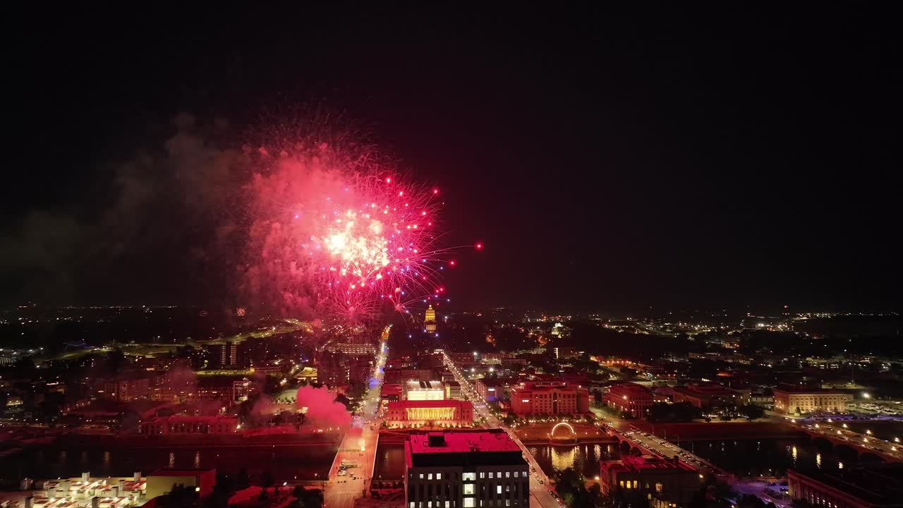 des moines, iowa fuegos artificiales sobre la ciudad y el edificio del capitolio estatal en el día de la independencia con video de drones moviéndose en plano ancho