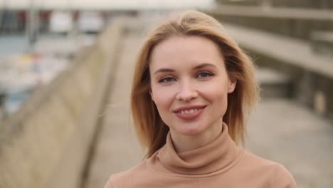 smiling woman walking along seafront.