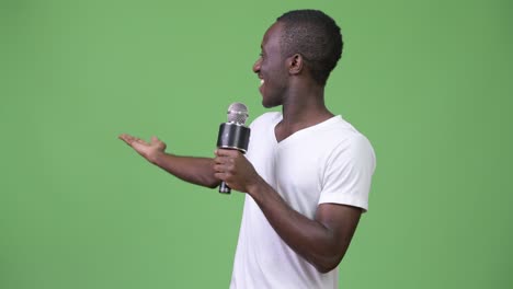 joven africano feliz sonriendo mientras habla en el micrófono