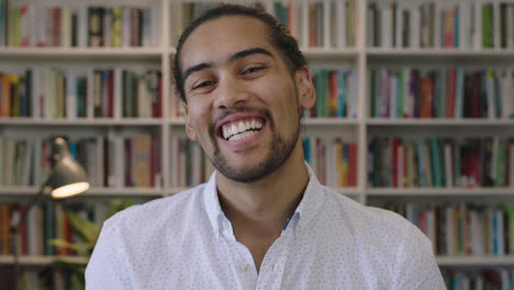 close-up-portrait-of-attractive-young-hispanic-man-student-laughing-cheerful-in-library-study-background-enjoying-learning-education