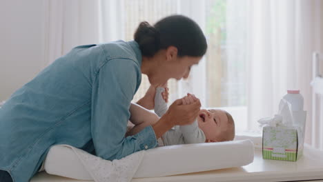 happy mother gently kissing baby enjoying loving mom playfully caring for toddler on changing table at home sharing connection with her newborn child healthy childcare