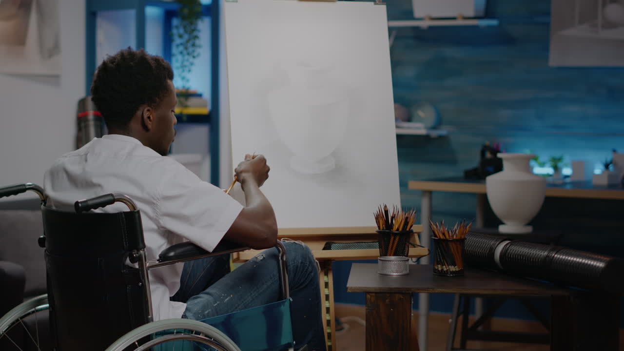 Black person with handicap using pencil on white canvas
