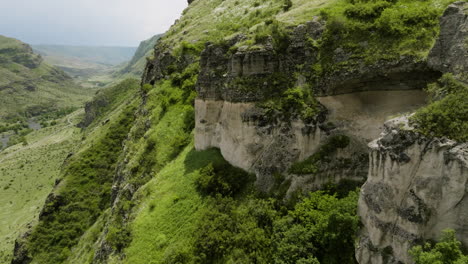 Fly-By-The-Rocky-Mountains-Along-The-Flowing-River-Near-Khertvisi-Fortress-In-Meskheti,-Georgia