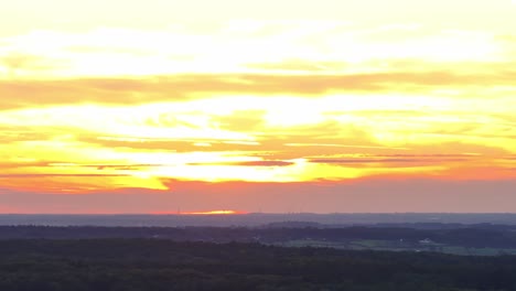 skyline covered in orange, red and yellow over dark landscape below