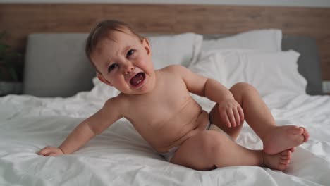 video de una niña llorando sentada en la cama.