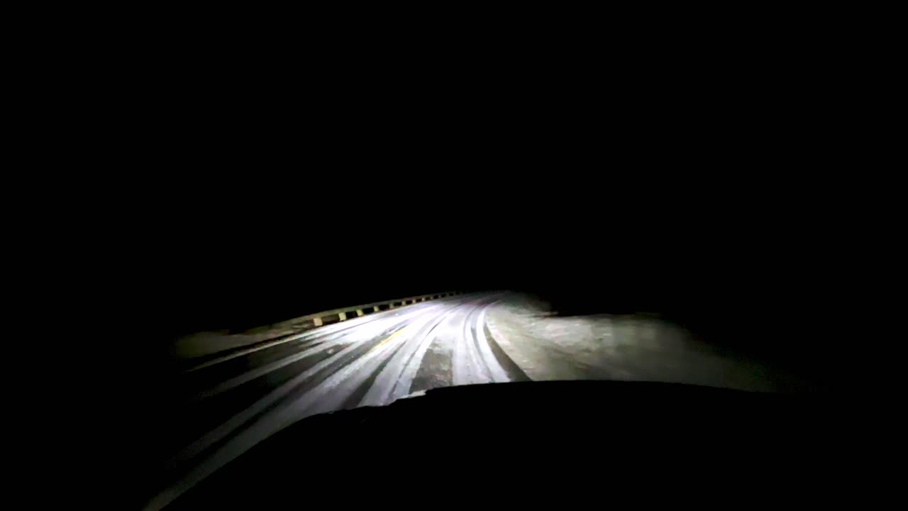 snow covered blue ridge parkway with headlights at night between boone nc and blowing rock north carolina