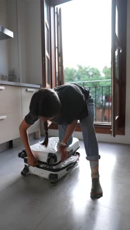 woman packing suitcase at home