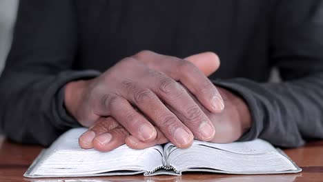 hombre negro orando a dios con la biblia en las manos hombre caribeño orando con el fondo con la gente stock video stock footage