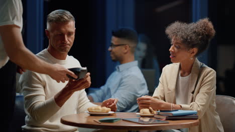 Businesswoman-and-businessman-meeting-in-coffee-shop.-Coworkers-discussing-tasks