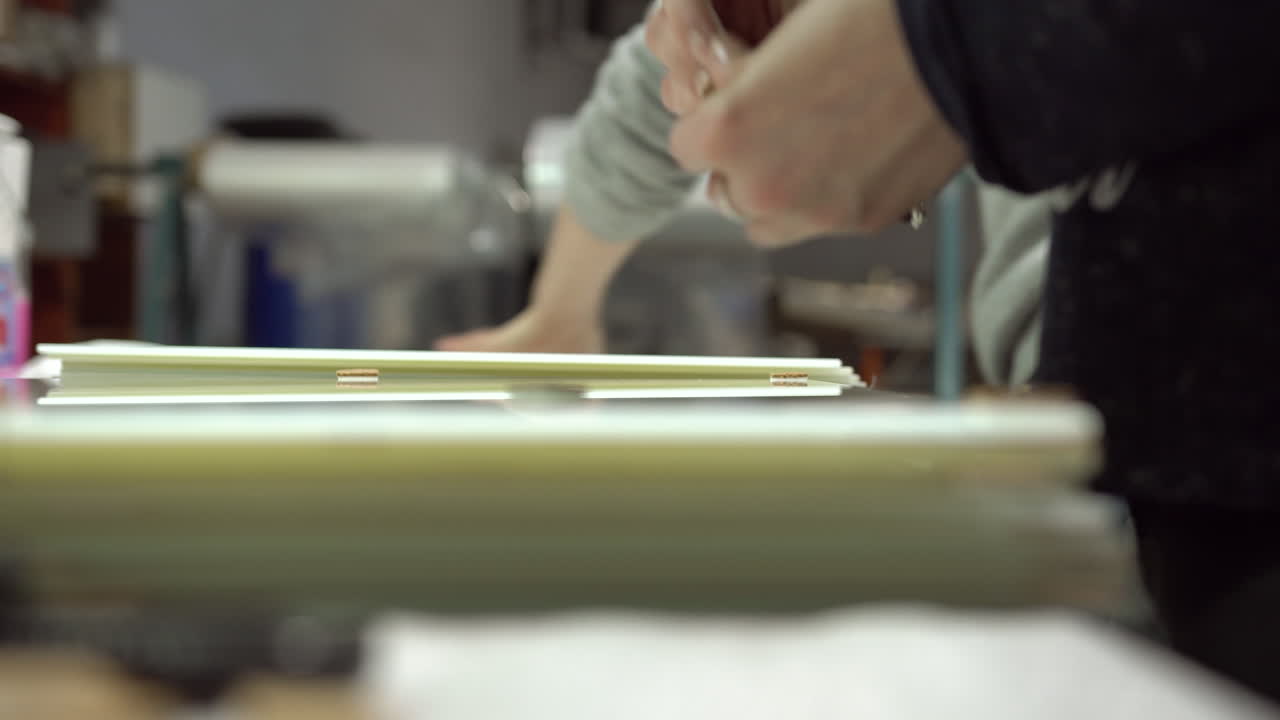 Worker stacking square glass panels on top of each other