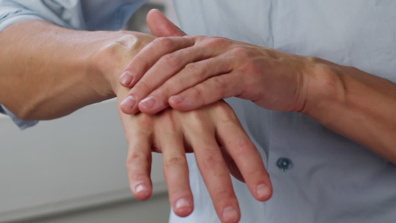 Young man smearing a white moisturizer on his hands close-up. Morning routine. Beauty and care concept.