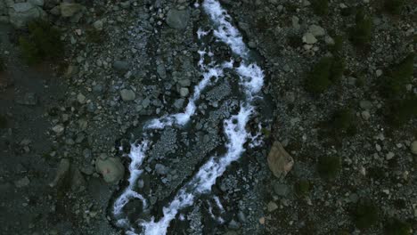 Overhead-aerial-shot-of-mountain-creek-in-Italian-Alps,-Alpe-Ventina,-rising