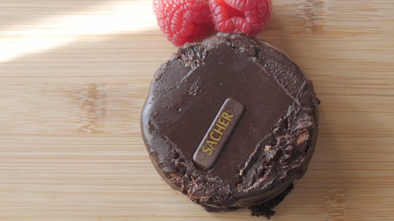 Sacher Torte with dark chocolate and raspberry garnish, showing close-up details