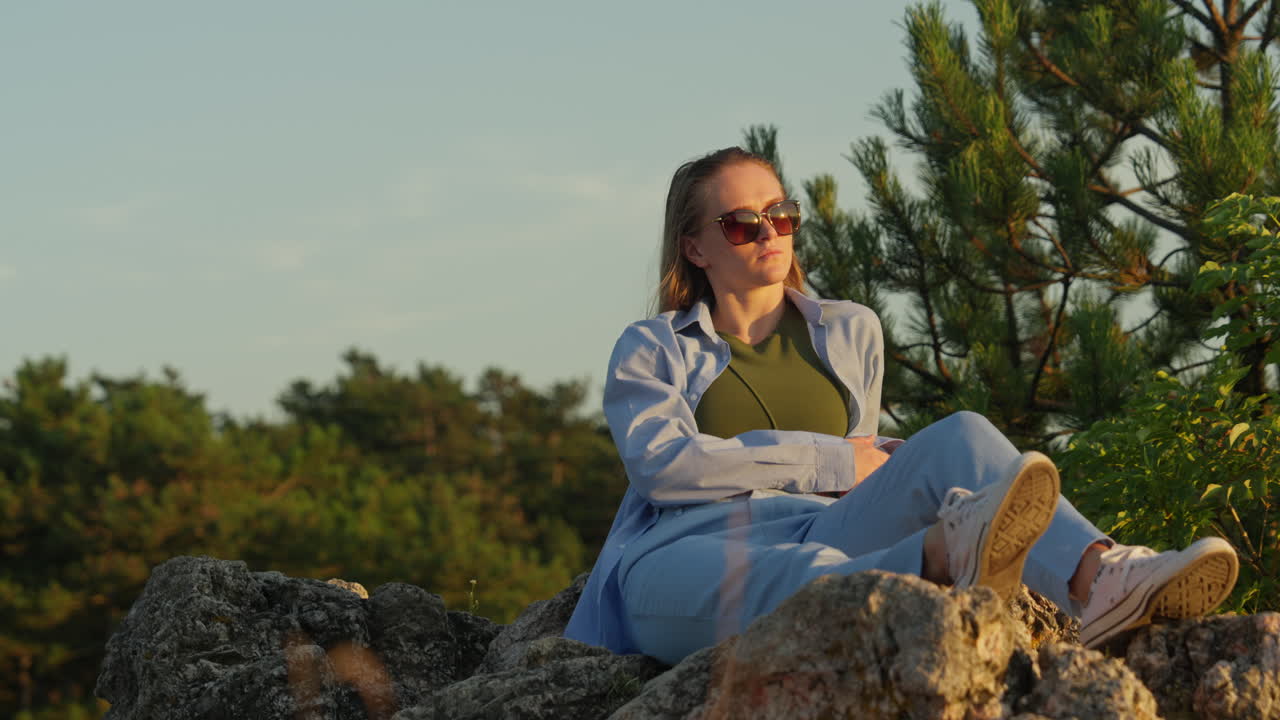 mujer joven sentada en las rocas, la naturaleza, la puesta de sol
