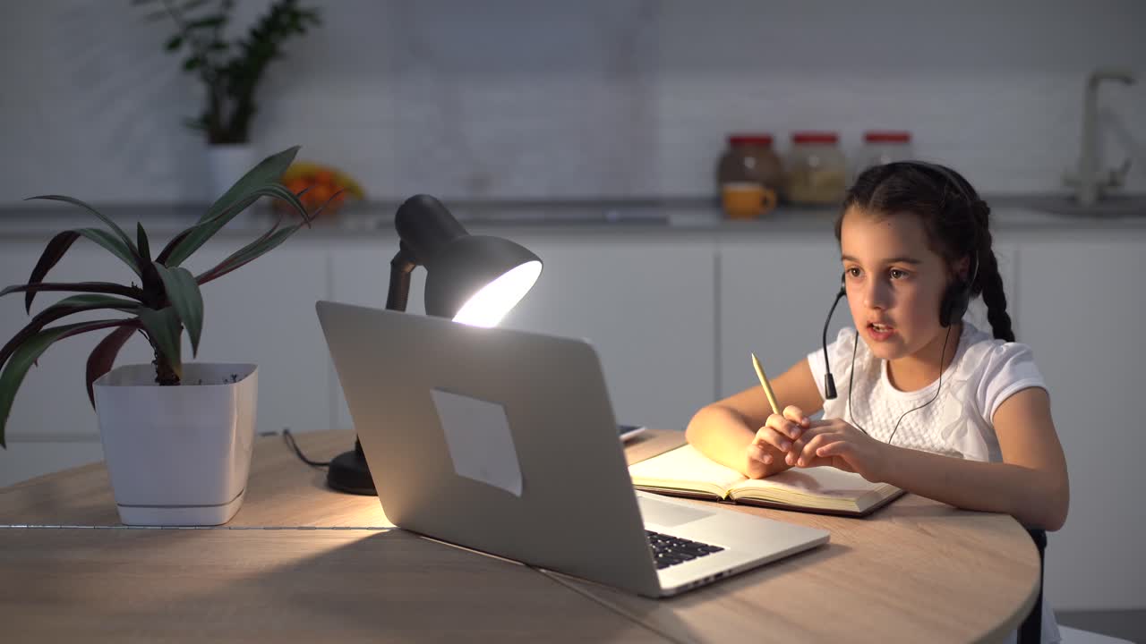 chica positiva estudio remoto sentarse en un escritorio usar una computadora portátil tener una lección de comunicación en línea con tutor escribir un informe en casa en el interior