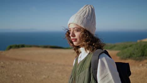 girl walking cliff edge on sunny day. happy tourist enjoying spring vacation