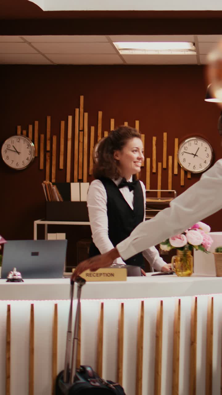 Video verticale: personale dell'hotel che offre la chiave magnetica