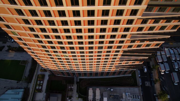 Vista aérea ascendente em frente às janelas de um prédio alto, pôr do sol em Nova York, EUA.