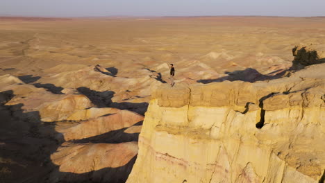 Man-Standing-On-The-Famous-White-Stupa-Cliff-In-Mongolia---Aerial-Drone-Shot