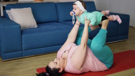 Weight-loss-of-the-body-of-a-young-mother.-Woman-with-child-doing-exercises-on-mat