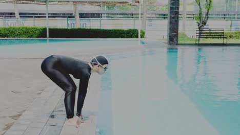 professional asian woman swimmer in black swimsuit and swim goggle is preparing to jump into the water