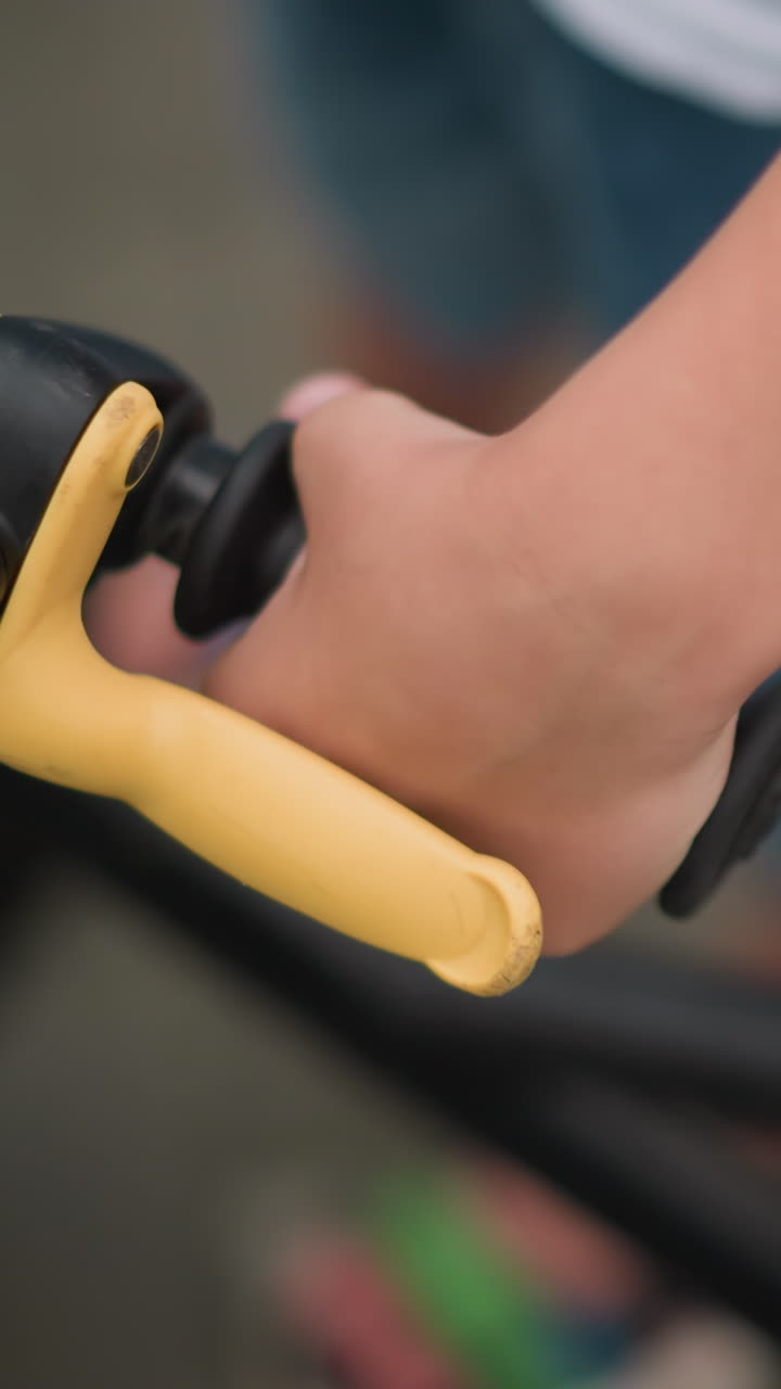 un primer plano de la mano de un niño agarrando el manillar de una bicicleta