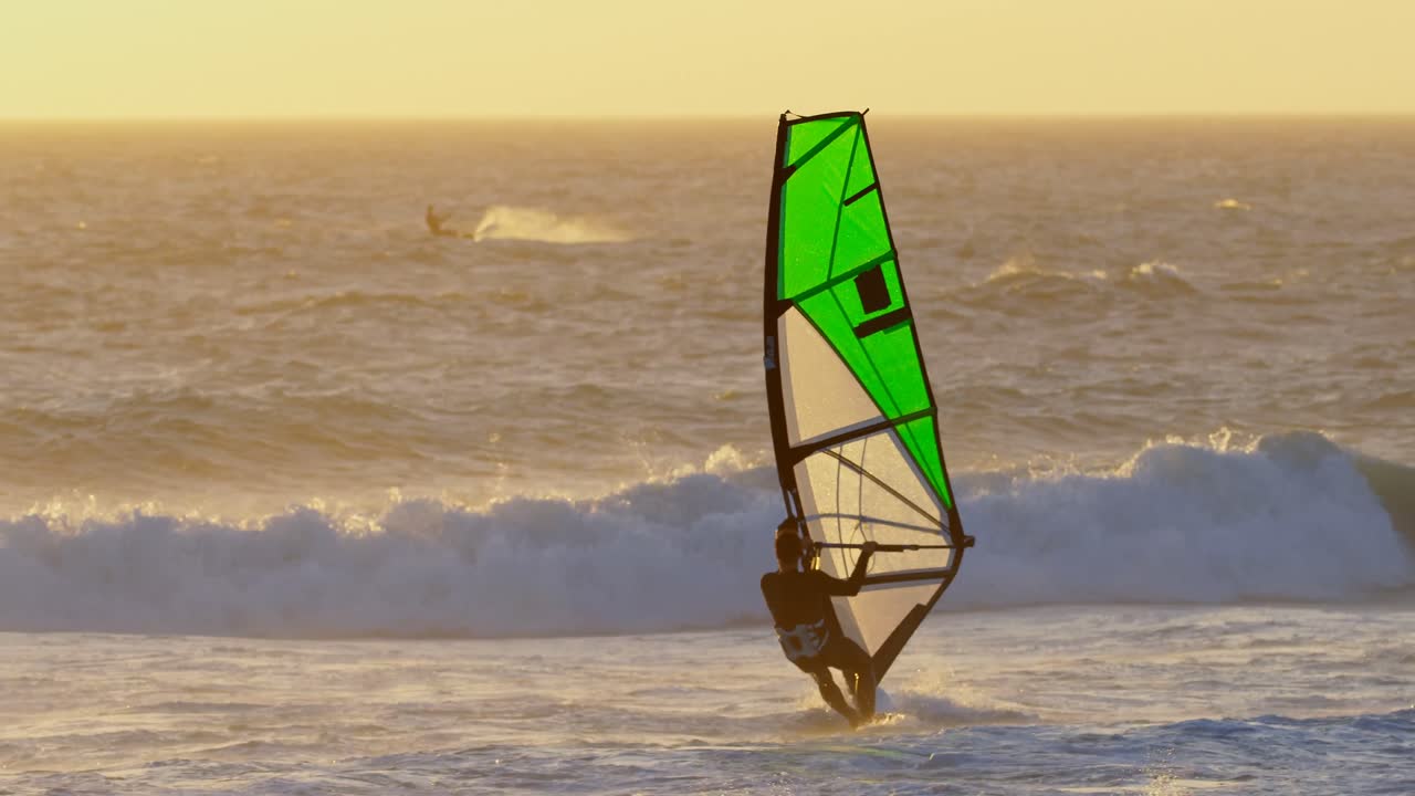 surfista masculino haciendo windsurf en la playa 4k