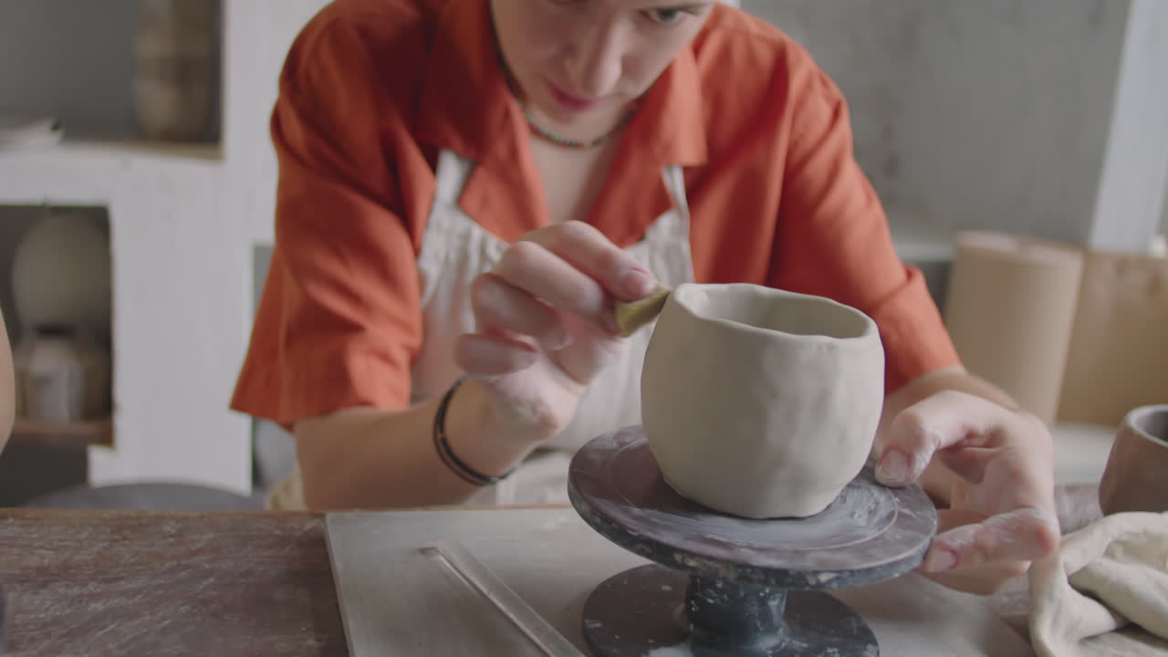 Woman Glazing Ceramic Mug on Pottery Wheel