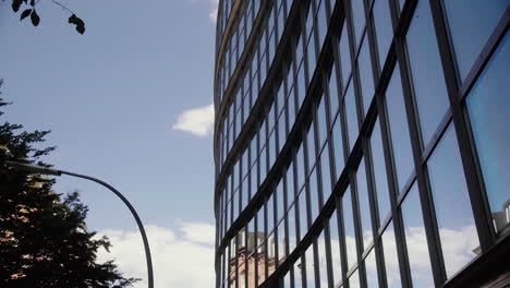 Glass-Front-of-Office-Building-against-the-blue-sky-with-clouds-passing-by-1