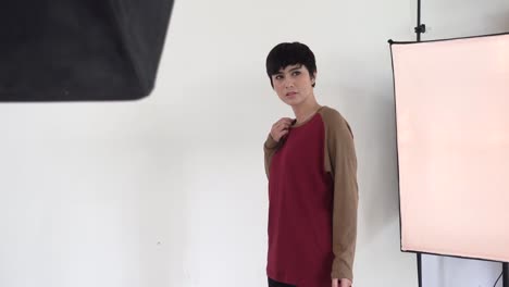 detrás de escena en una sesión de fotos, hermosa modelo asiática posando para el catálogo de moda