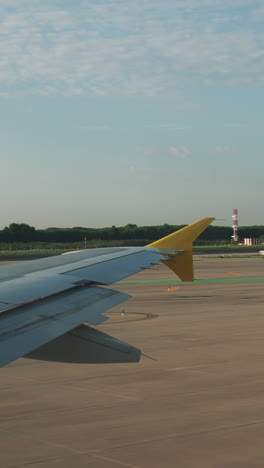 view from a plane window of taxiing around airport in shot in vertical