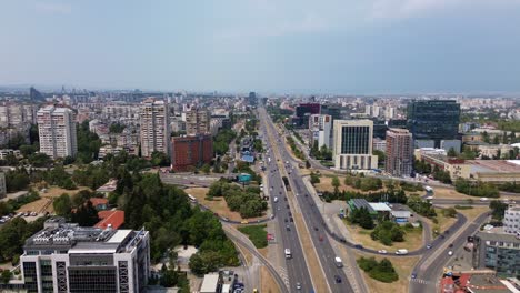 drone, rising above а cloverleaf interchange at one of the main boulevards leading into sofia, the capital city of bulgaria, on a cloudy day in the summer. the car traffic at tsarigradsko shose blvd
