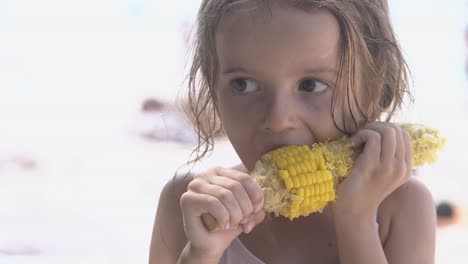 Una-Linda-Niña-Con-Grandes-Ojos-Marrones-Roe-Una-Gran-Mazorca-De-Maíz