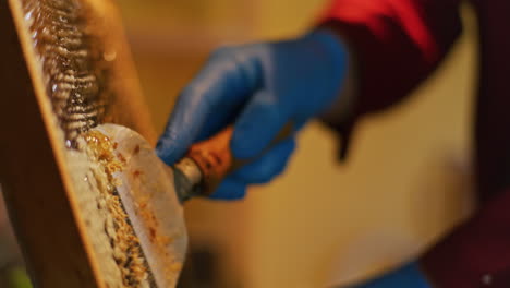 a beekeeper removes wax from honeycomb