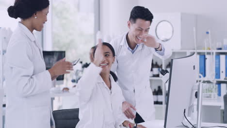 team of scientists celebrating with high five