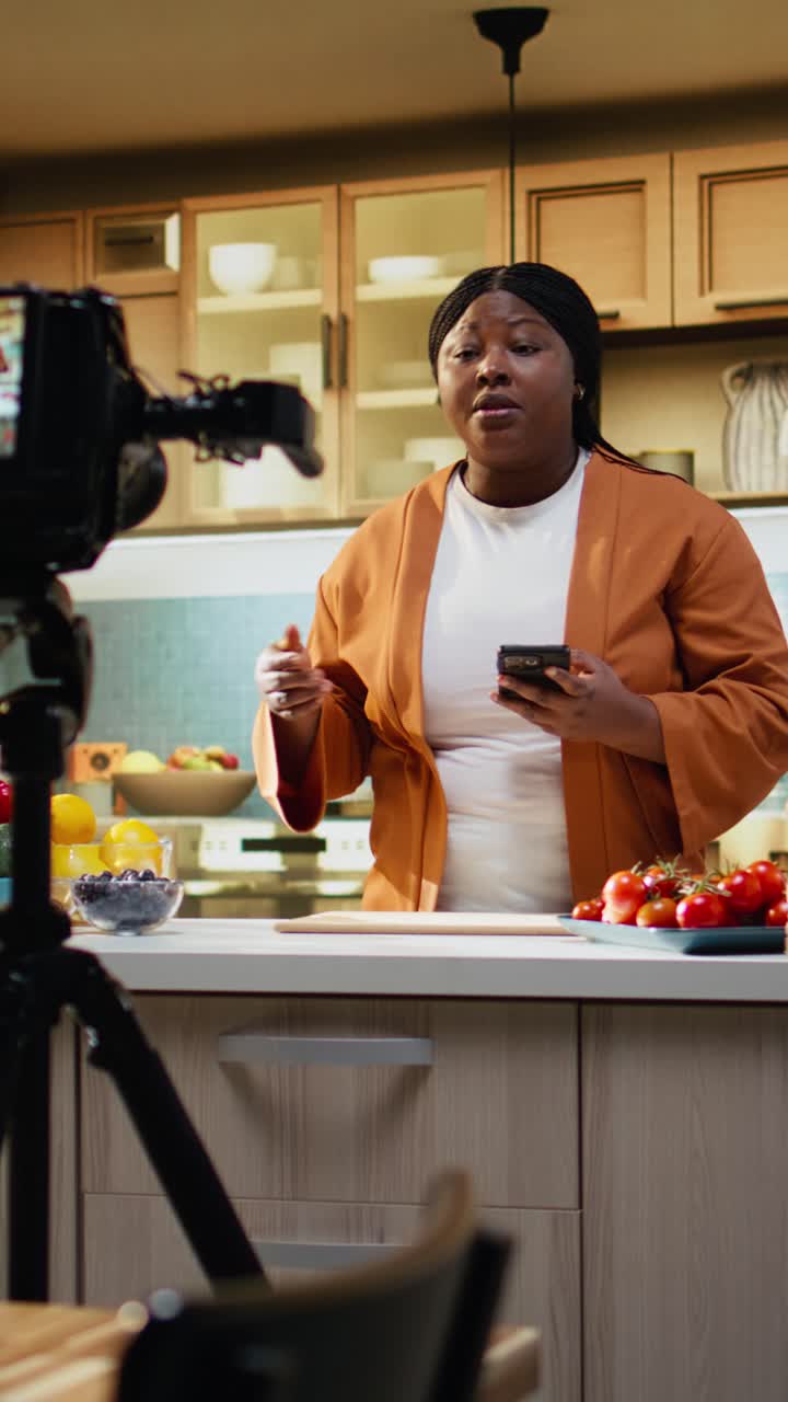 Video verticale: vlog di cibo, dietro le quinte, donna afroamericana che riprende la ricetta di un piatto