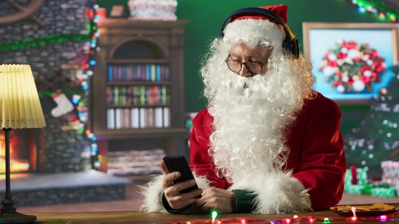 Santa using smartphone and headphones during Christmas