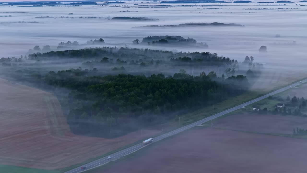 Aerial view of foggy countryside landscape at dawn, serene and peaceful