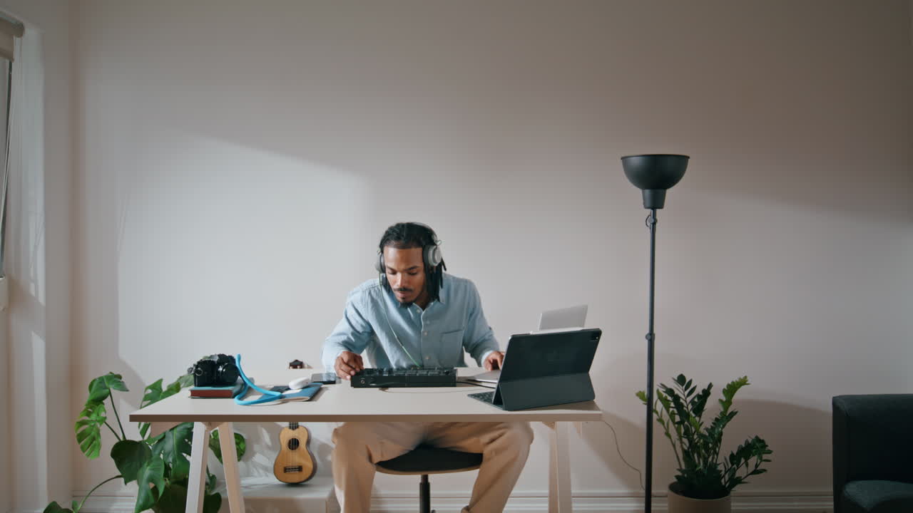 Sound producer creating music home. Involved man using dj console looking tablet