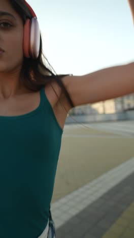 teenage girl dancing outdoors with headphones