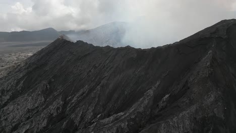 sobrevuelo aéreo, cráter volcánico lleno de niebla y humo en el monte bromo, java, indonesia