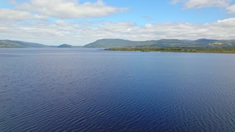 aerial view dolly in of two people kayaking on huillinco lake in chiloe, chile