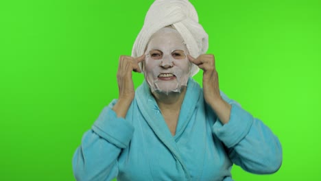 abuela anciana después de la ducha. anciana aplicando máscara facial de tela cosmética