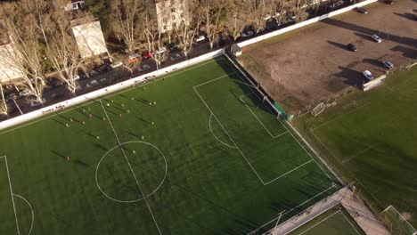 amateur soccer players playing football match on buenos aires green field at sunset