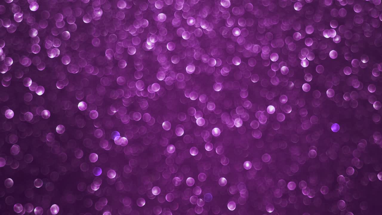 Abstract background of colorful bright pink defocused bokeh lights spin and flicker. Glowing pink particles on a pink background rotate through the air for a vibrant holiday presentation with circular bokeh effects.