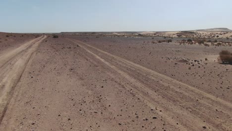 Drone-flying-along-dirt-road-of-Erfoud-desert-in-Morocco