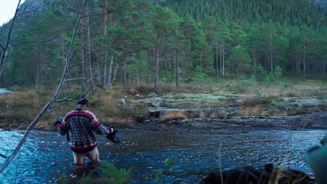 a man across fast flowing river in forest