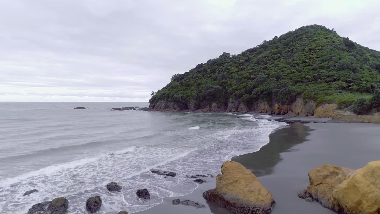 playa escondida remota en la costa salvaje de nueva zelanda en un día nublado, antena