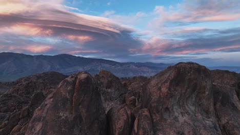 Die-Schönsten-Rosa-Linsenwolken-Und-Ein-Einsamer-Vogel,-Der-Durch-Diese-Felsige-Szene-Der-Alabama-Hills-Fliegt